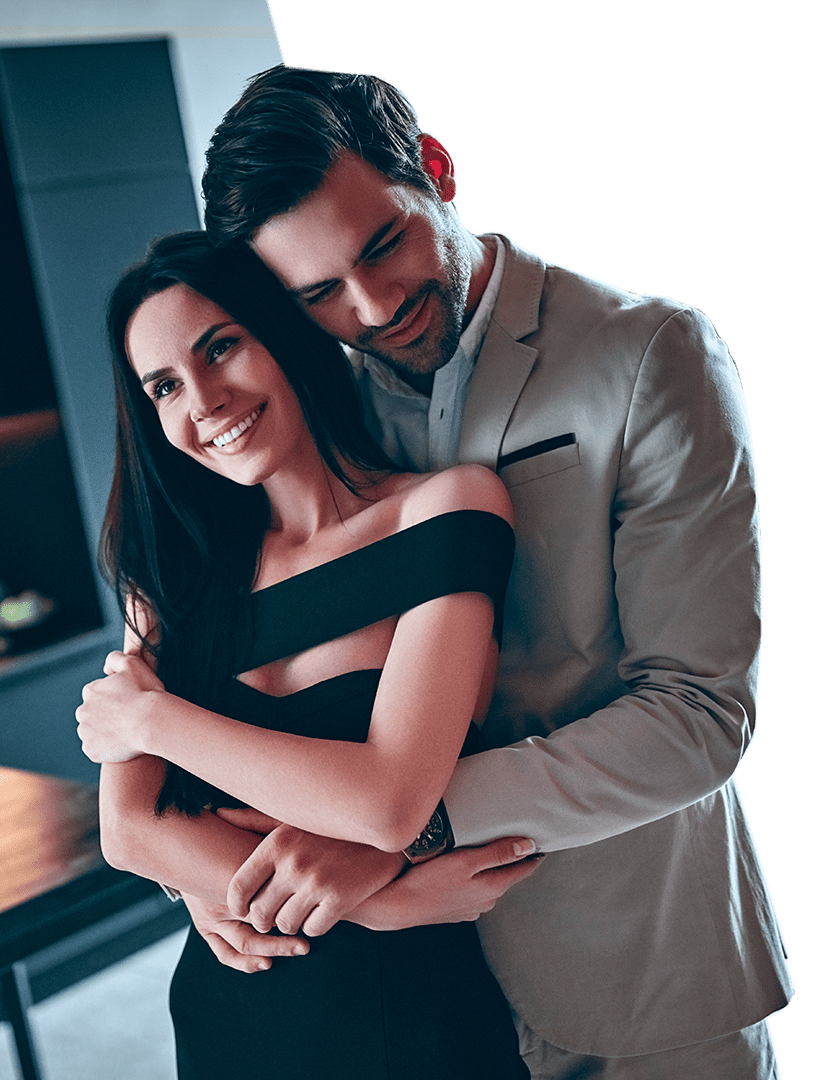 Casal abraçado com um apartamento no fundo